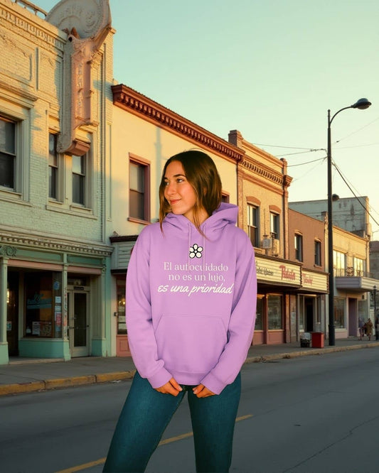 Mujer usando hoodie NARA “El autocuidado no es un lujo”, ambiente acogedor – imagen 1