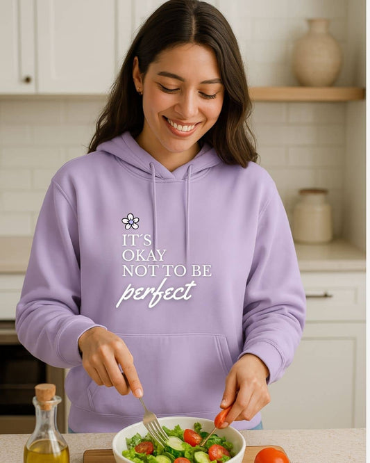 Modelo con hoodie NARA “It’s OK not to be perfect”, luz suave y gesto tranquilo – imagen 2