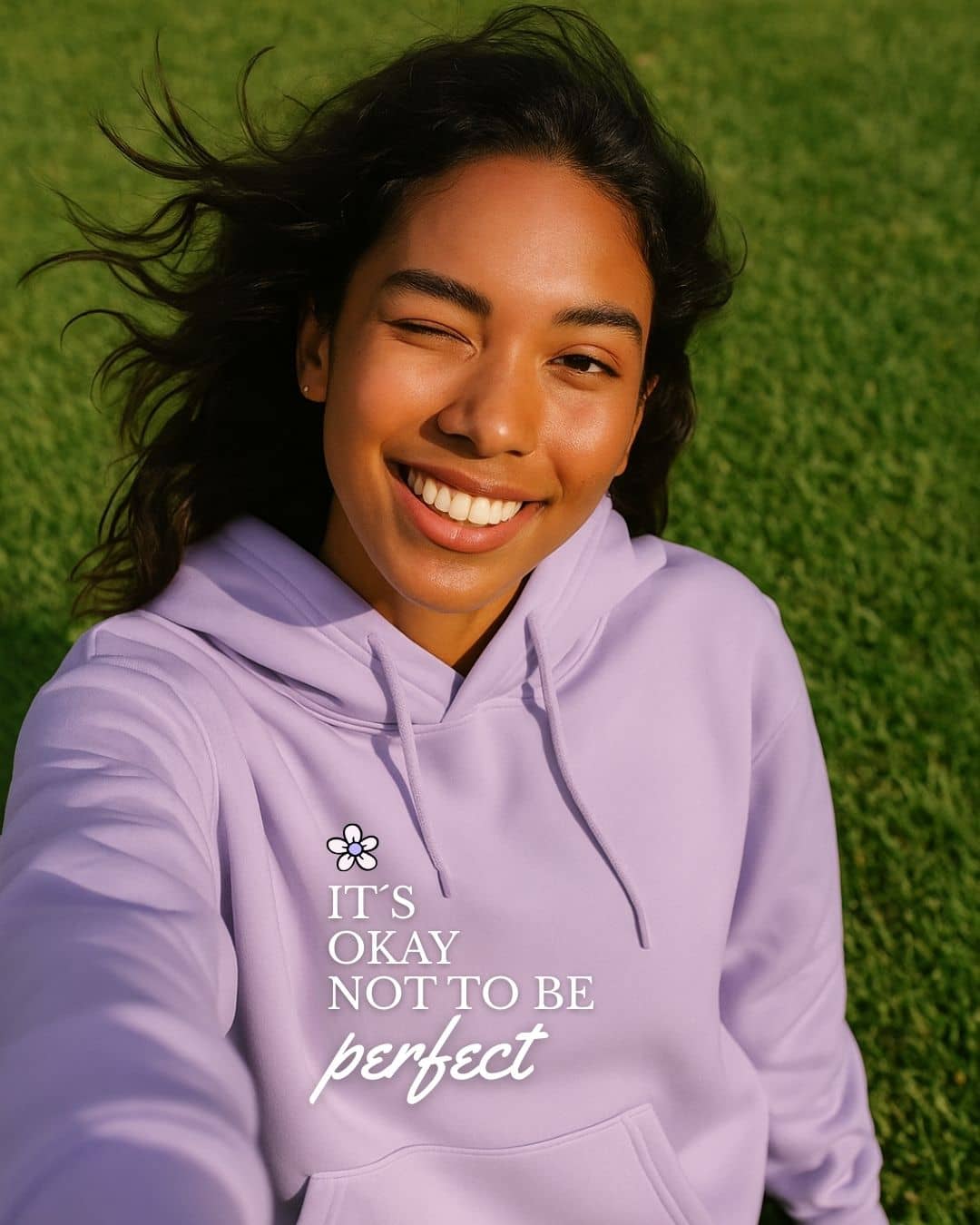Modelo con hoodie NARA “It’s OK not to be perfect”, luz suave y gesto tranquilo – imagen 3